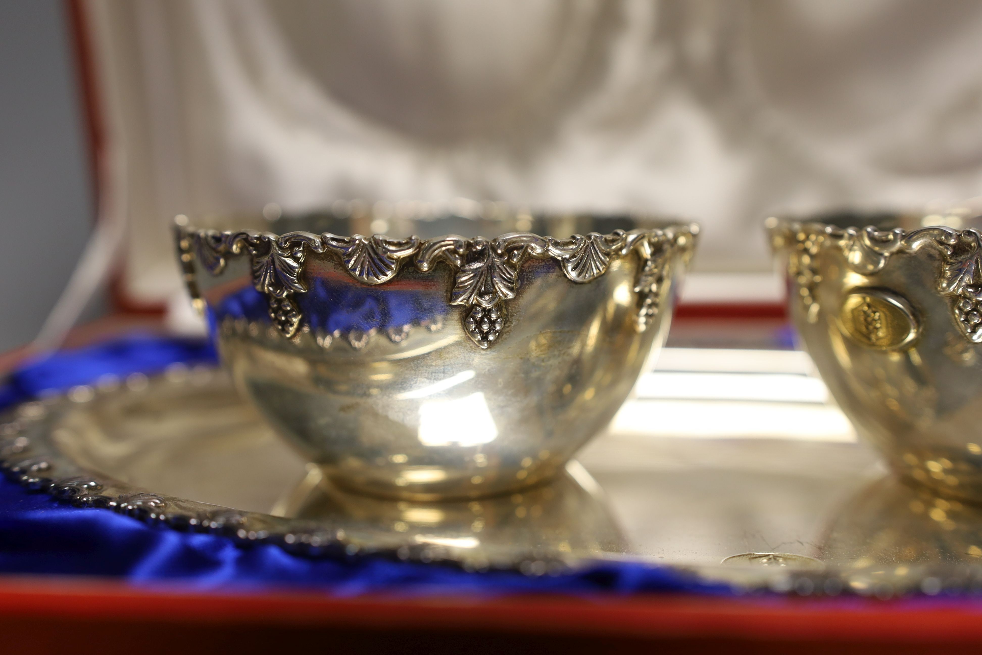 A cased Middle Eastern white metal oval serving dish and pair of matching finger bowls, dish, 27.7cm, 17oz.